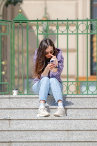 Girl on stairs watching her smartphone